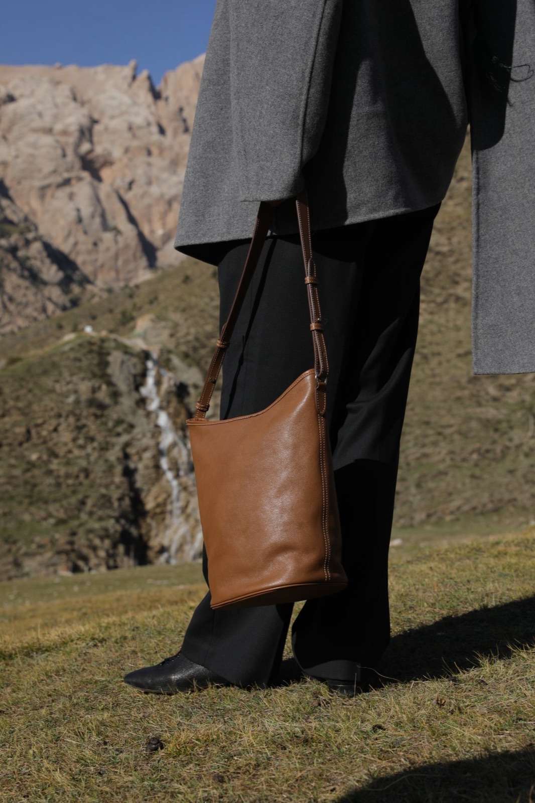 Tan full-grain leather bucket bag with adjustable strap